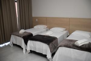 Hotel Tibério Filho tesisinde bir odada yatak veya yataklar