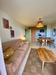 a living room with a couch and a table at Hôtel Golf Fontcaude in Montpellier