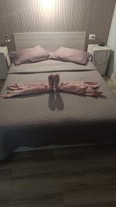 a bed with two pink sheets and bows on it at Magda in Constanţa