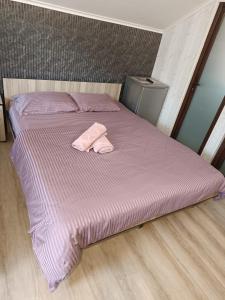 a pink bed with a pink towel on it at Magda in Constanţa