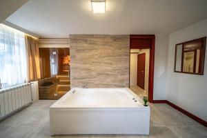 a large white bath tub in a room with a staircase at Divski Resort in Divčibare