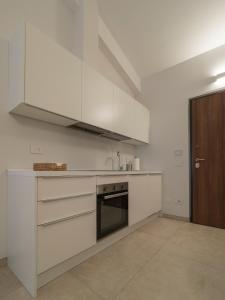 a kitchen with white cabinets and a sink at Palombarone Resort in Matelica