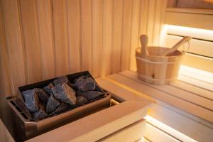 a box of rocks in a sauna with a wooden container at Divski Resort in Divčibare