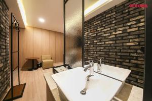 a bathroom with a sink and a brick wall at 월호텔 in Cheonan +49 photos