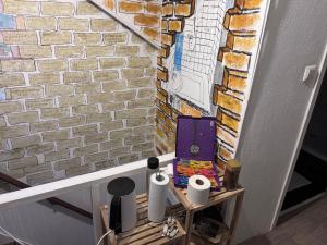 a room with a brick wall and a table with toilet paper at Guesthouse Czaar Peter in Zaandam