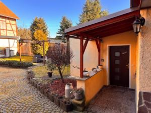 a small house with a black door and a driveway at Ferienwohnung Am Schleizer Dreieck in Schleiz