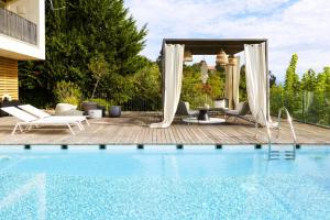 a pool with chairs and a gazebo at Villa Alma Vista in Dobrovo
