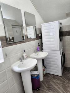 a bathroom with two sinks and a mirror and a microwave at Hostel Mojan in Andrijevica +47 photos