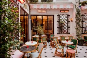 a patio with tables and chairs in front of a building at Hôtel Grand Amour in Paris
