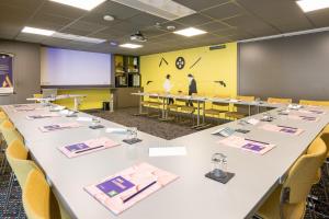 a conference room with a long table and chairs at ibis budget Lyon Centre Confluence in Lyon