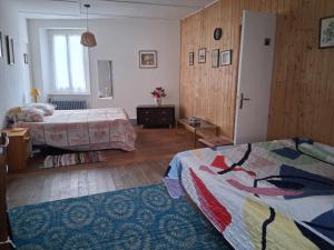a hotel room with two beds and a window at La maison du Thoré in Saint-Amans-Valtoret