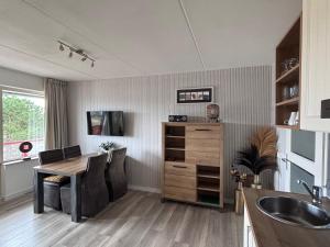 a kitchen with a dining room table and a sink at Amelander Paradijs Ferienwohnung in Buren