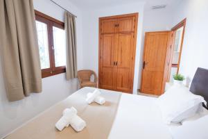 a bedroom with a large white bed with two towels at Apartamentos Gravina in Tarifa +247 photos