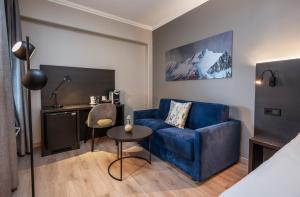 a living room with a blue couch and a table at Thon Hotel Baronen in Ålesund