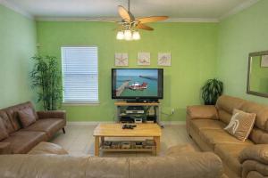 a living room with a couch and a flat screen tv at Los Cabos I #5 condo in South Padre Island