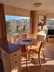 a kitchen and dining room with a table and chairs at Bella May Mobile Home in Ballintra
