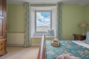 a bedroom with a bed and a window at Tanderra Coniston in Coniston