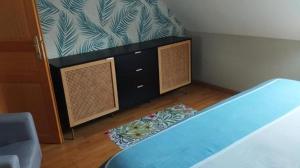 a bedroom with a blue bed and a dresser at Nuit etoile et jacuzzi prive in Pleuven