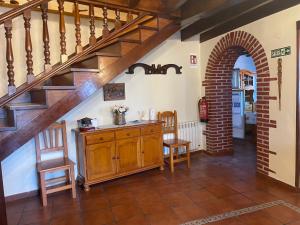 a kitchen with a staircase and a table and chairs at Casa Rural La Xana in Piloña