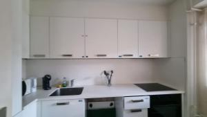 a kitchen with white cabinets and a sink at Zimmer In Luzern in Arni Alp