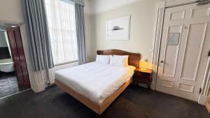 a small bedroom with a bed and a window at Brighton House in Brighton & Hove