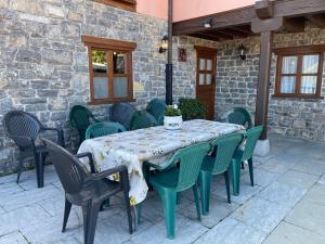 a green table and chairs on a patio at Casa Rural La Xana in Piloña