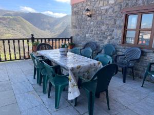 a table and chairs on a patio with mountains in the background at Casa Rural La Xana in Piloña