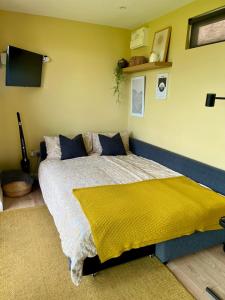a bedroom with a bed with a yellow wall at Square 32 Luxury Shipping container in Knockcloghrim +31 photos