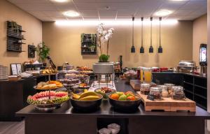 a buffet with bowls of fruit on a counter at Thon Hotel Baronen in Ålesund