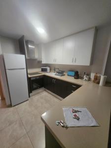 a kitchen with white cabinets and a white refrigerator at Las Jarcias 2C in Moncófar +7 photos