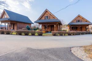 two log homes with a driveway in front of them at Hotel Ranč u Edyho in Námestovo