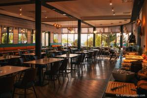 a restaurant with tables and chairs and windows at Rodzinne Resorty Karkonosze in Wojcieszyce