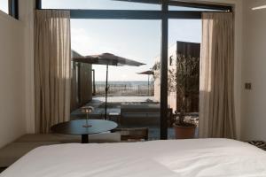 a bedroom with a bed and a view of the beach at Piatti beach suites in Zandvoort