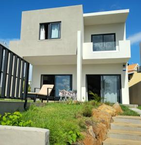 a white house with black windows and a balcony at Entire villa with private pool and seaview Albion Mauritius in Albion
