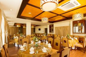 Seaside Resort Vung Tau في فنغ تاو: غرفة طعام بها طاولات وكراسي وثريا