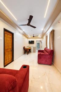 a living room with a red couch and a table at Vizag Urban Nest in Visakhapatnam