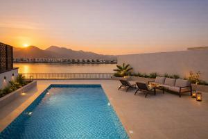a swimming pool on a patio with a view of the water at Seascape Villa Marine in Fujairah