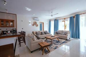 a living room with two couches and a table at Spacious 3 bedroom ensuite villa Pazuri vipingo in Mombasa