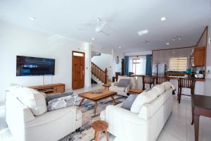 a living room with two white couches and a kitchen at Spacious 3 bedroom ensuite villa Pazuri vipingo in Mombasa