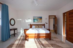 a bedroom with a bed and a table and a mirror at Spacious 3 bedroom ensuite villa Pazuri vipingo in Mombasa +16 photos