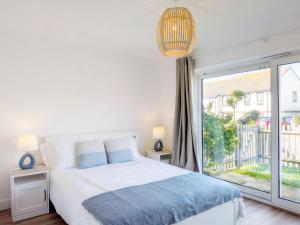 a bedroom with a bed and a large window at The Beach Flat - Selsey in Selsey