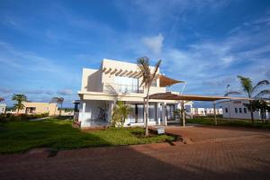 a white house with a palm tree in front of it at Spacious 3 bedroom ensuite villa Pazuri vipingo in Mombasa