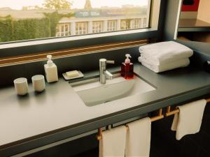 a bathroom counter with a sink and a window at Casa Camper Berlin in Berlin +26 photos