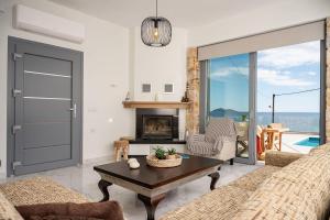a living room with a couch and a table at Villa Alexia - Private Pool & Panoramic Sea Views in Órmos Koumaíïkon