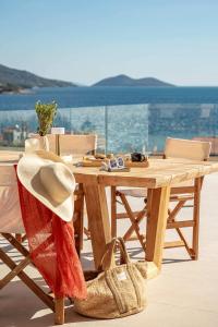 a wooden table with a hat on top of a balcony at Villa Alexia - Private Pool & Panoramic Sea Views in Órmos Koumaíïkon +30 photos