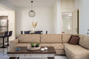 a living room with a couch and a table at Villa Alexia - Private Pool & Panoramic Sea Views in Órmos Koumaíïkon