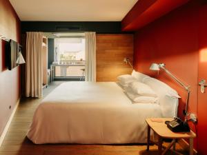 a bedroom with a white bed and a red wall at Casa Camper Berlin in Berlin