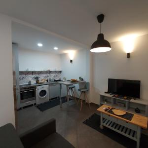 a living room with a kitchen with a table and a tv at Hidden place in pure center in Novi Sad
