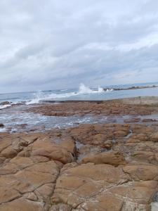 a rocky beach with the ocean in the background at The Victorian Villa in Chintsa