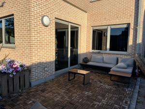 a patio with a couch and a coffee table at Casa Leopardo in Hasselt +8 photos